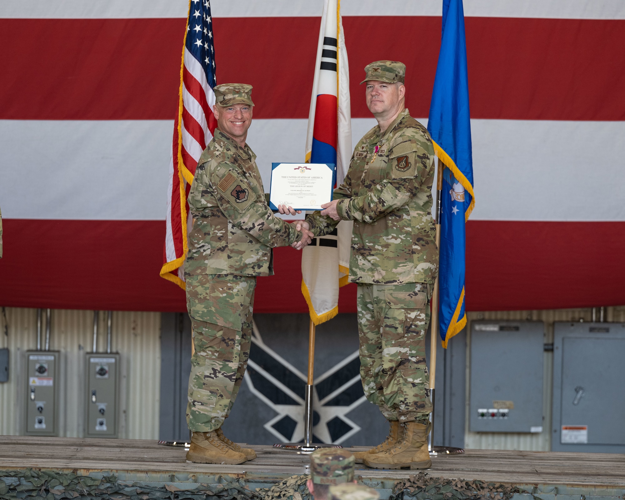 Col. Matthew Gaetke, left, 8th Fighter Wing commander, presents Col. Bradley Altman, right, 8th Maintenance Group outgoing commander, with the Legion of Merit certificate during the 8th MXG change of command ceremony at Kunsan Air Base, Republic of Korea.