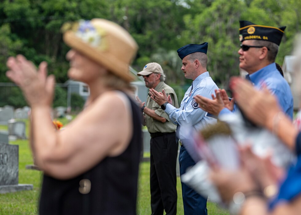 U.S. Air Force Staff Sgt. Zachary McPherson, 23rd Wing command chief executive assistant, and event attendees clap at the Sunset Hill Cemetery Memorial Day service in Valdosta, Georgia, May 27, 2024. The ceremony honored those who have made the ultimate sacrifice while serving in the U.S. armed forces. (U.S. Air Force photo by Airman 1st Class Leonid Soubbotine)