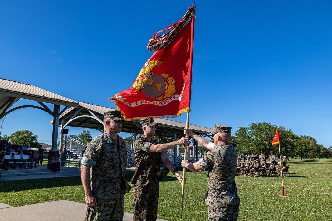 U.S. Marine Corps Col. James B. Reid, the incoming Commanding Officer of the 26th Marine Expeditionary Unit (Special Operations Capable) (26MEU(SOC)) passes the battalion colors to Sgt. Maj. Christopher Taylor, the 26th MEU(SOC) Sergeant Major, during a change of command ceremony on Marine Corps Base Camp Lejeune, North Carolina, May 22, 2024. A change of command ceremony signifies the transfer of responsibility, authority and accountability from the outgoing commanding officer to the oncoming commanding officer. (U.S. Marine Corps photo by Sgt. Nayelly Nieves-Nieves)