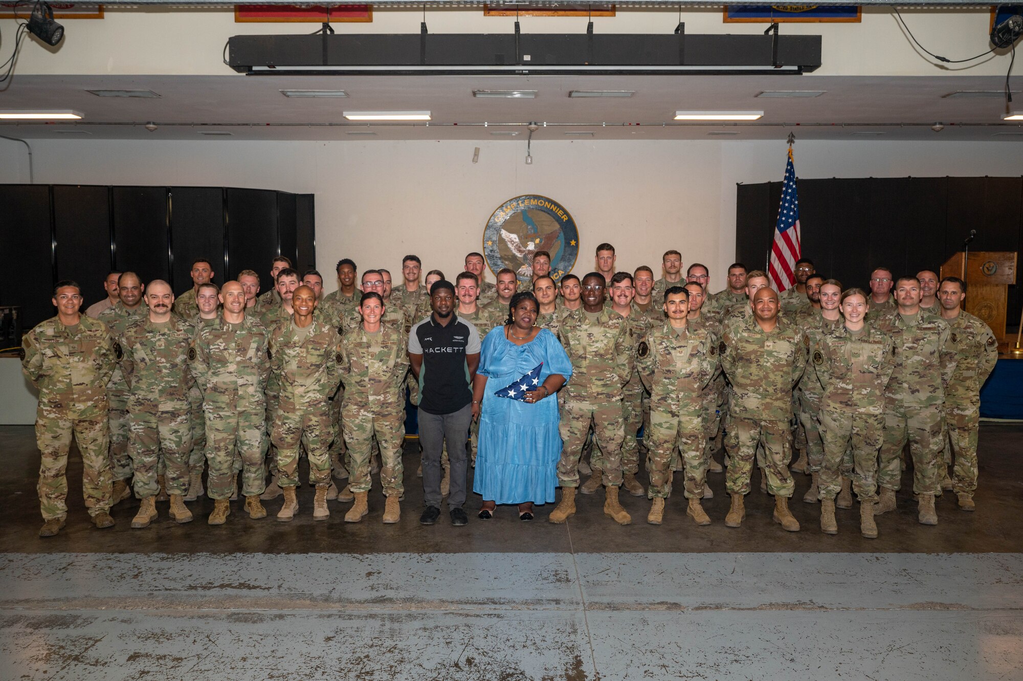 Group photo of U.S. servicemembers posing with the mother and brother of one of their Airmen.