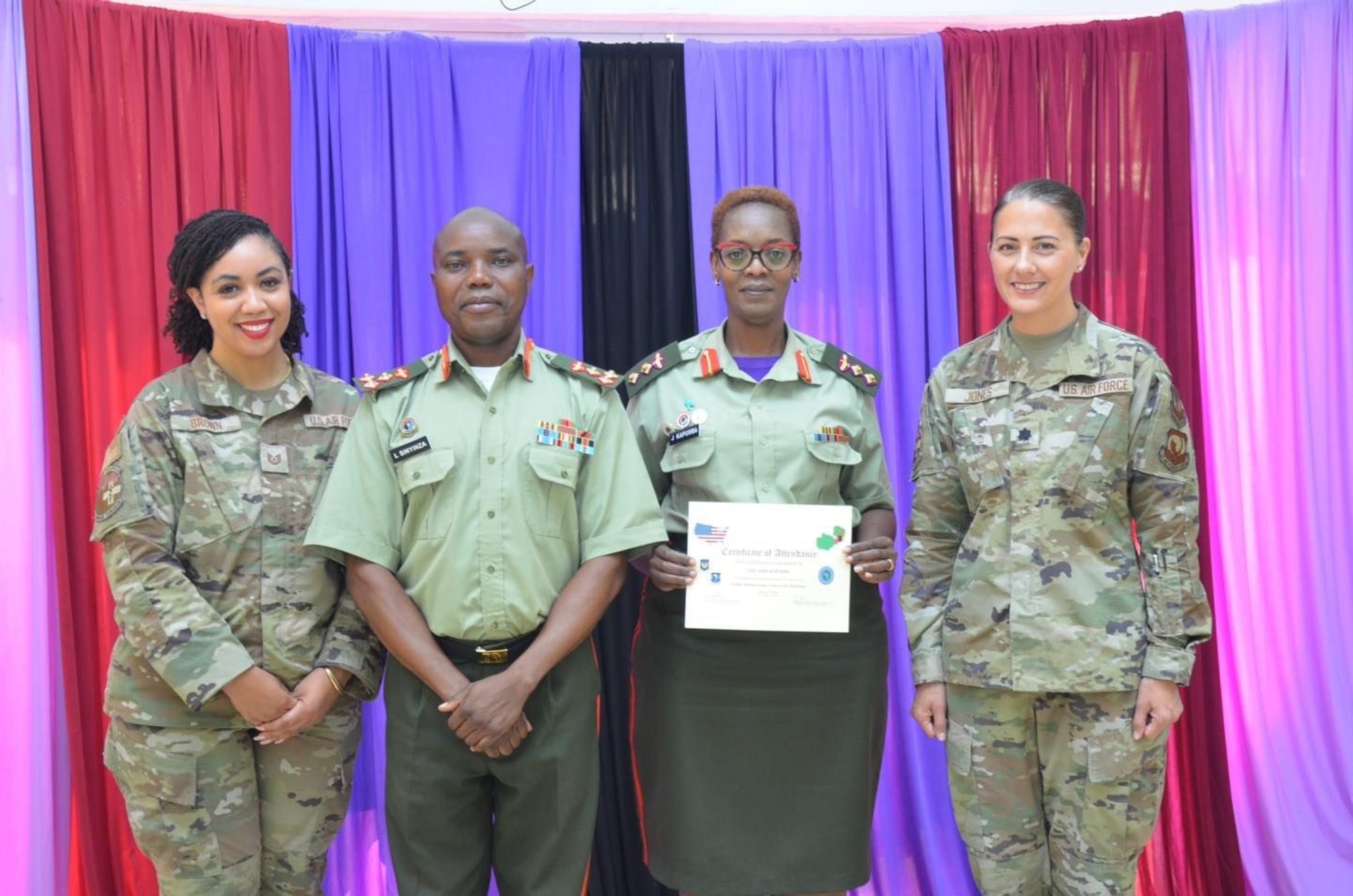 Lt Col Linda Jones and TSgt Samara Brown, international health specialists, present certificates to participants with ZDF presiding officer, Gen Sinyinza