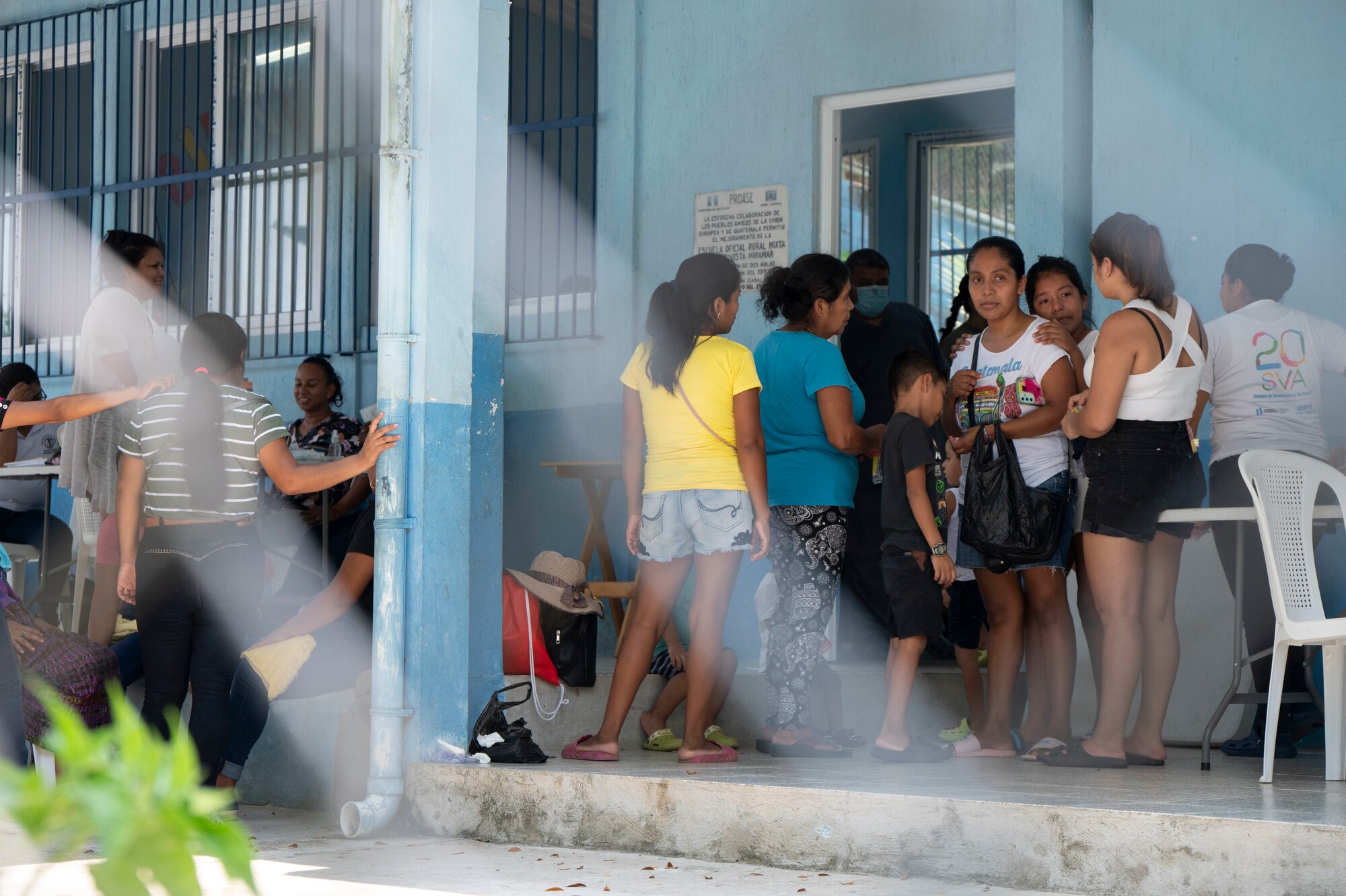 A photo of a group of people waiting outside a building.