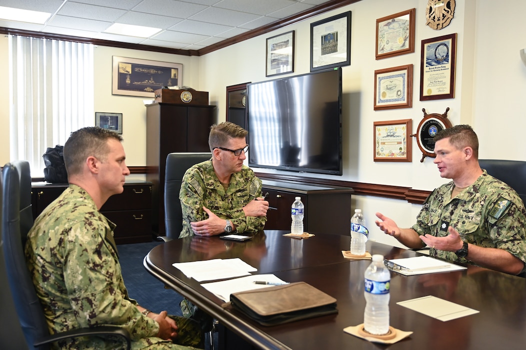Cmdr. Chris Dumas, executive officer, Center for Information Warfare Training (right) and Cmdr. Pete Manzoli, commanding officer, Information Warfare Training Command Corry Station (left) , gives an overview of Information Warfare training to Rear Adm. Ralph R. “Russ” Smith, Deputy Director of Operations for Combat Support, National security Agency (center), during a visit to CIWT, May 16, 2024.