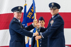 Two airmen hold guideon during change of command ceremony