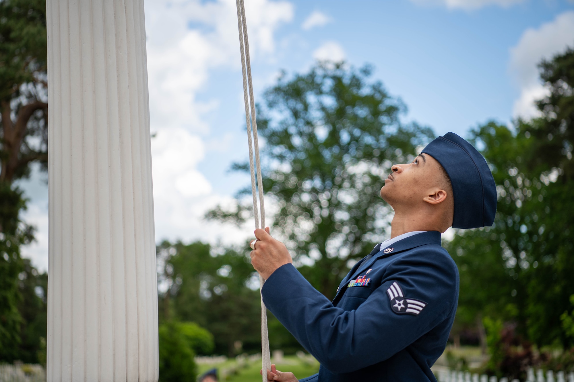An Airman adjusts a flag during a Memorial Day ceremony