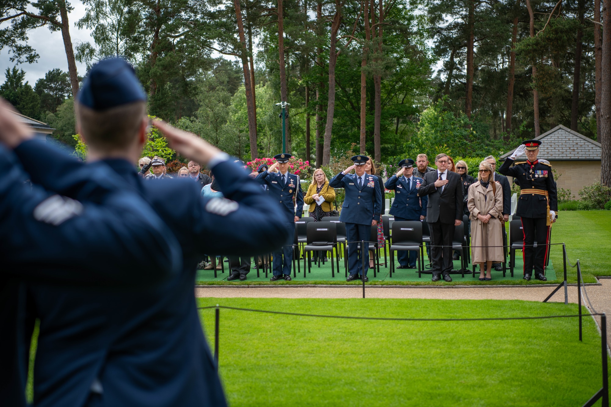 Armed forces members salute during a Memorial Day ceremony