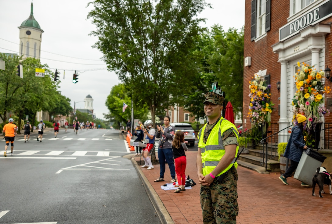 A U.S. Marine and spectators cheer for the runners during the 17th annual Marine Corps Historic Half in Fredericksburg Virginia, May 19, 2024. The historic half is a 13.1-mile race that generates community goodwill, fosters public relations, and increases advocacy for individual health while emphasizing the Marine Corps’ warrior ethos. (U.S. Marine Corps photo by James H. Frank)