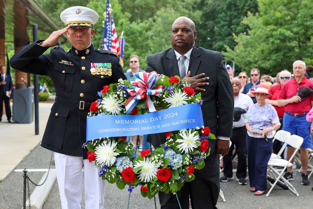 U.S. Marine Corps Lt. Col. Gerard Vanderwaal, the commanding officer for Security Battalion, and Jason Miyares, the 48th Attorney General of Virginia, give their respects for the playing of Taps during the 2024 Memorial Day Ceremony at the National Memorial Cemetery at Quantico, Triangle, VA, May 27, 2024. Memorial Day is a National Day of Remembrance to the service members who have given ultimate sacrifice. (U.S. Marine Corps photo by Sgt. Miranda C. DeKorte)