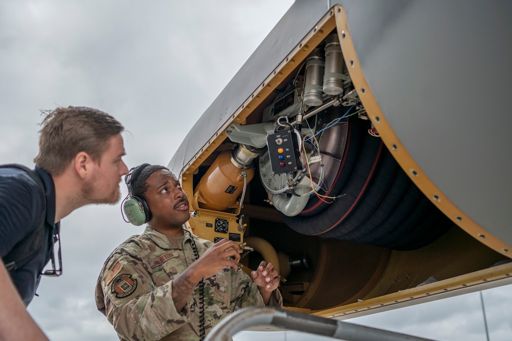 U.S. Air Force Staff Sgt. Kamron Houston, 71st Rescue Generation Squadron hydraulics systems craftsman, explains the parts of in-flight refueling pod hydraulic reel on an HC-130J Combat King II to a Mercer Engineering Research Center engineer at Moody Air Force Base, Georgia, May 20, 2024. A team of engineers from Mercer Engineering Research Center came down to Moody to conduct maintenance interviews and collect data about the processes and issues of the in-flight refueling system and in-flight refueling hose deficiencies. (U.S. Air Force photo by Airman 1st Class Leonid Soubbotine)