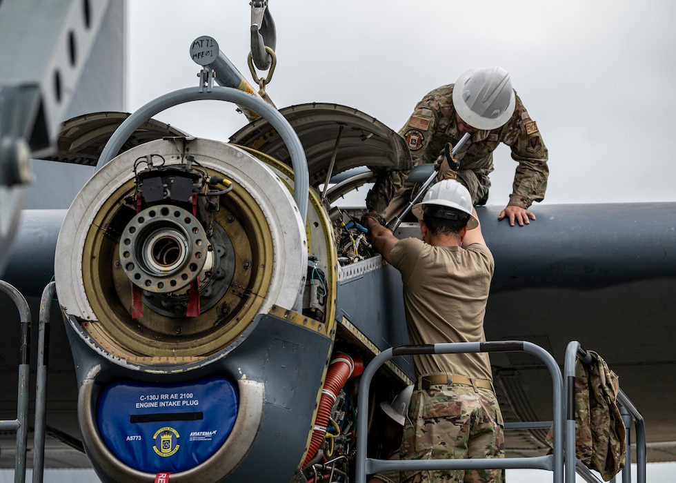 U.S. Air Force Airman 1st Class Christopher Mascuro, top, and Airman 1st Class Jacob Kenotich assigned to the 71st Rescue Generation Squadron work an HC-130J Combat King II engine at Moody Air Force Base, Georgia, May 20, 2024. Several teams of maintainers were able to replace the HC-130 engine in under one day. (U.S. Air Force photo by Airman 1st Class Leonid Soubbotine)