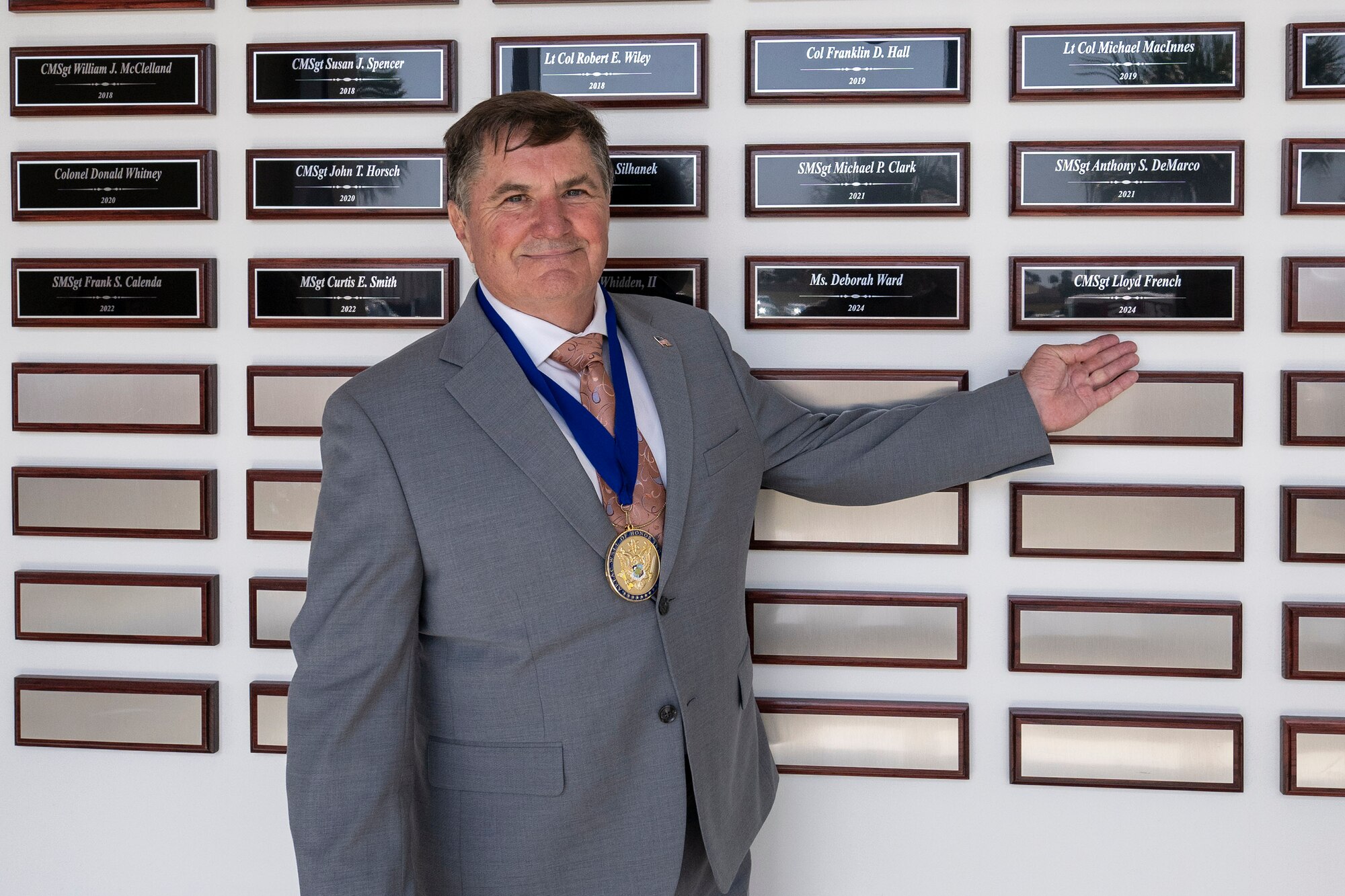 Retired U.S. Air Force Chief Master Sgt. Lloyd French, points to his engraved plaque that is currently displayed on the Air Force Technical Applications Center’s Wall of Honor.  The former gamma spectroscopy technician was inducted to the wall during a ceremony held at the nuclear treaty monitoring center May 16, 2024 in front of more than 200 family, friends and former colleagues.  French spent 30 years with AFTAC, a rare distinction for an active duty military member to be assigned to the same unit for their entire career. (U.S. Air Force photo by Matthew S. Jurgens)