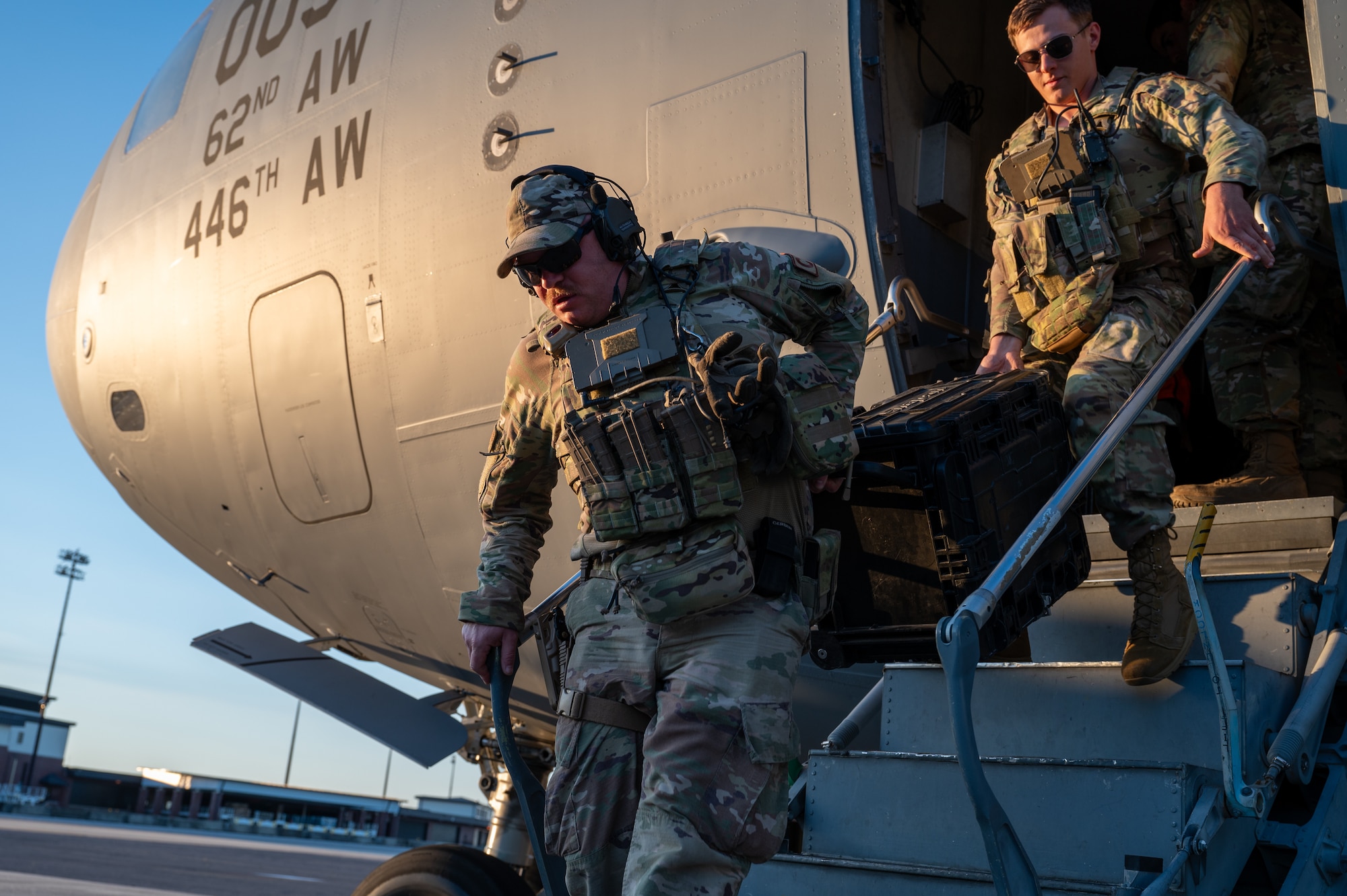 Men carry case out of air craft.