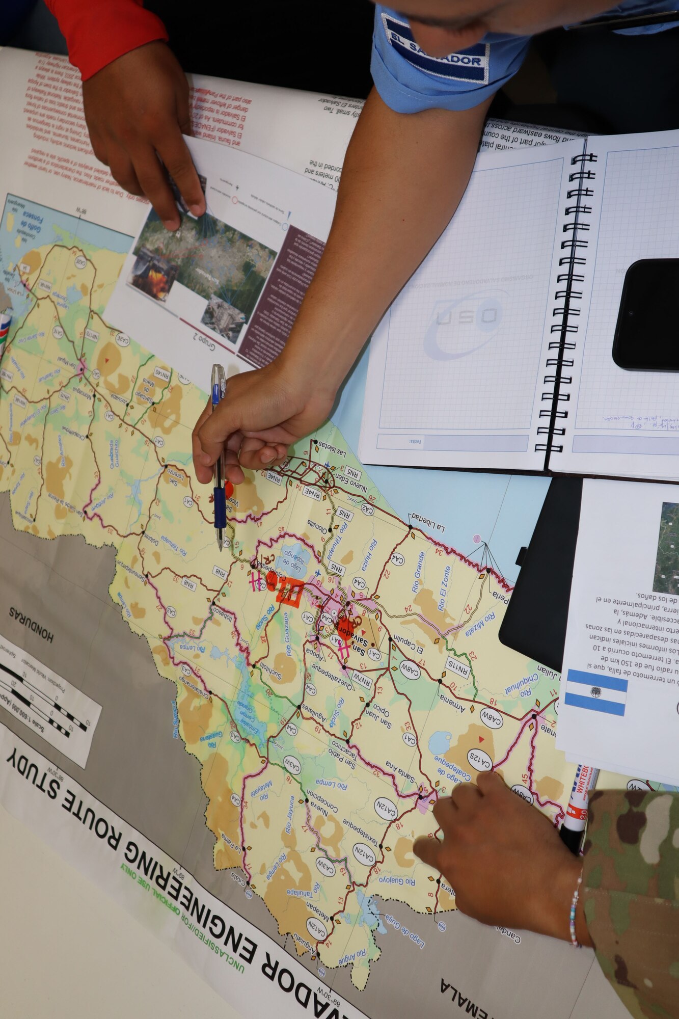 A photo of a map and people pointing to it.