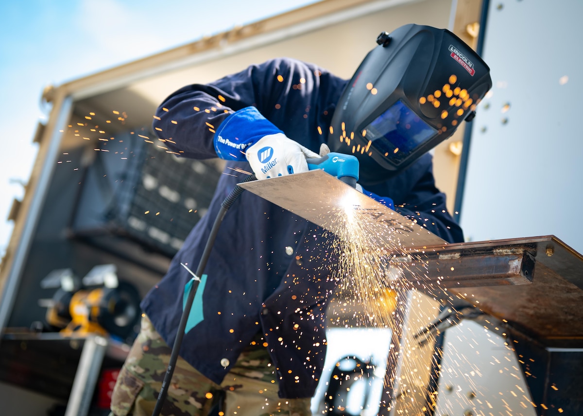 An Airman uses a plasma cutter
