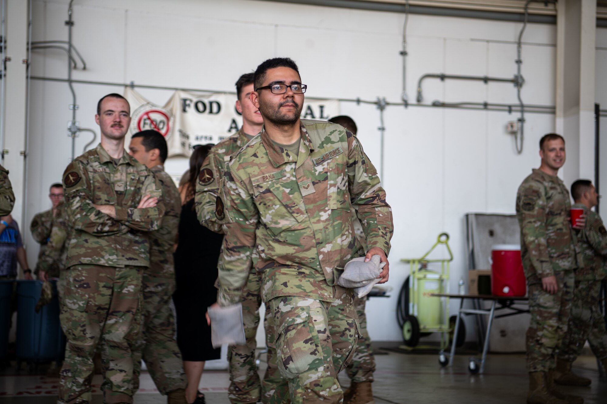 An airman tosses a bag while playing cornhole during the Maintenance Professional of the Year celebration.