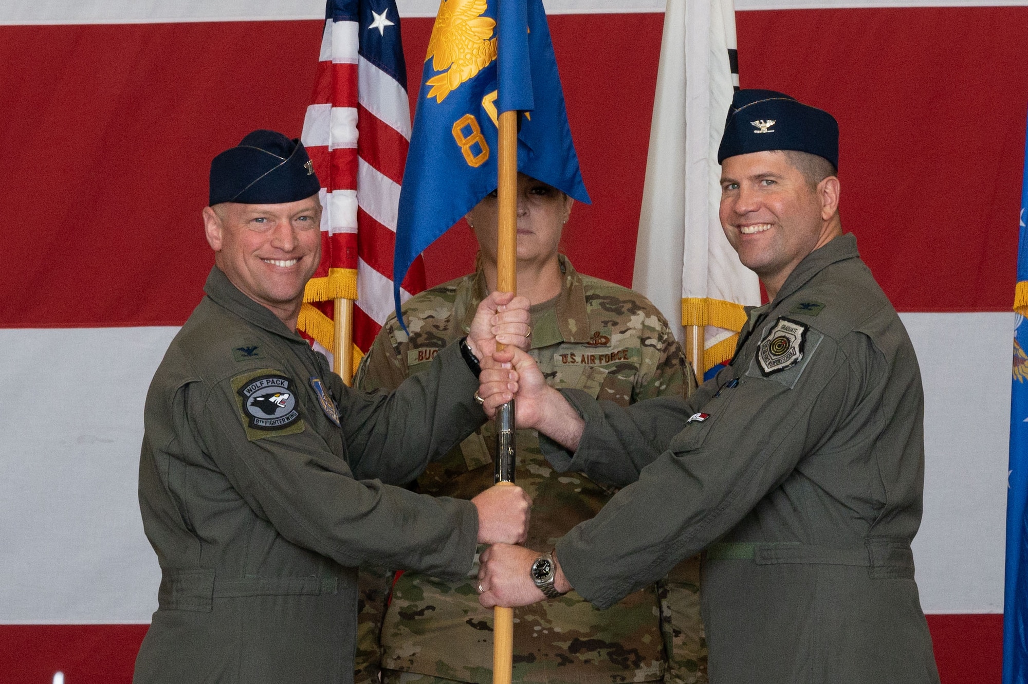 Col. Matthew Gaetke, left, 8th Fighter Wing commander, gives the guidon to Col. Derrick Franck, 8th Operations Group incoming commander, during the 8th OG change of command ceremony.