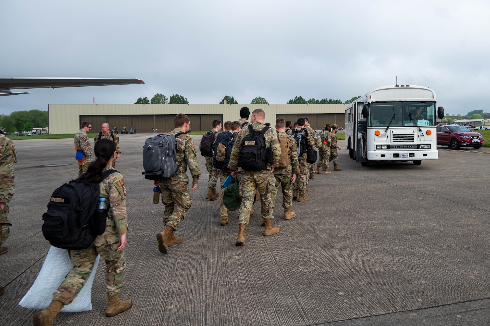 Airmen from Minot Air Base walk toward a bus at RAF Fairford