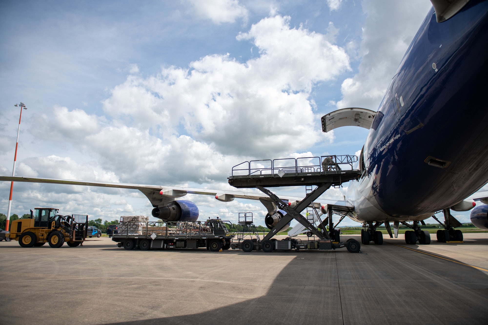 Two K-loaders and a 10K all terrain forklift work together to offload equipment from an Atlas Air Boeing 767 aircraft