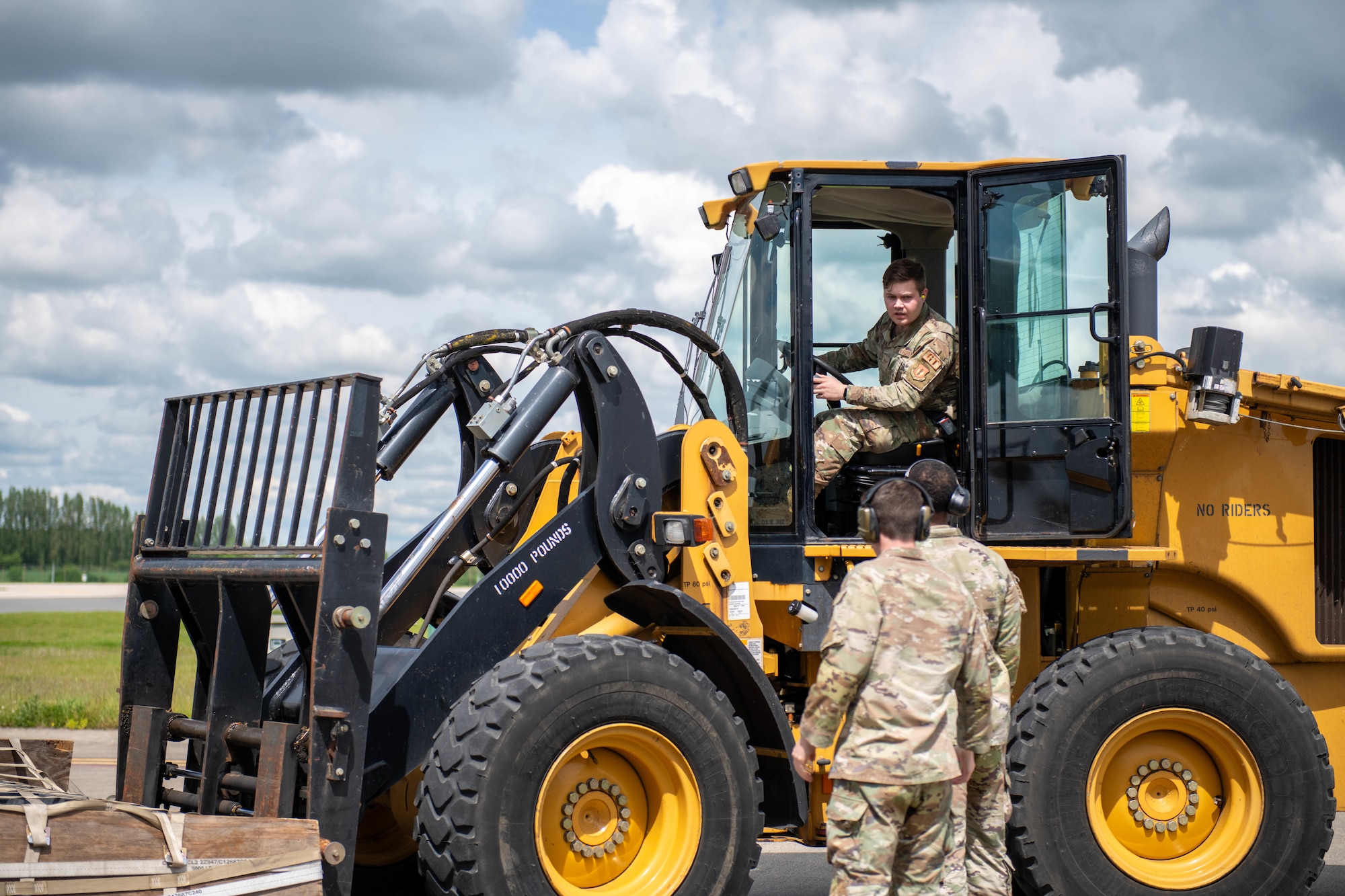 A Ground Transportation operator coordinates with Air Transportation Function Airmen while operating a 10K all terrain forklift