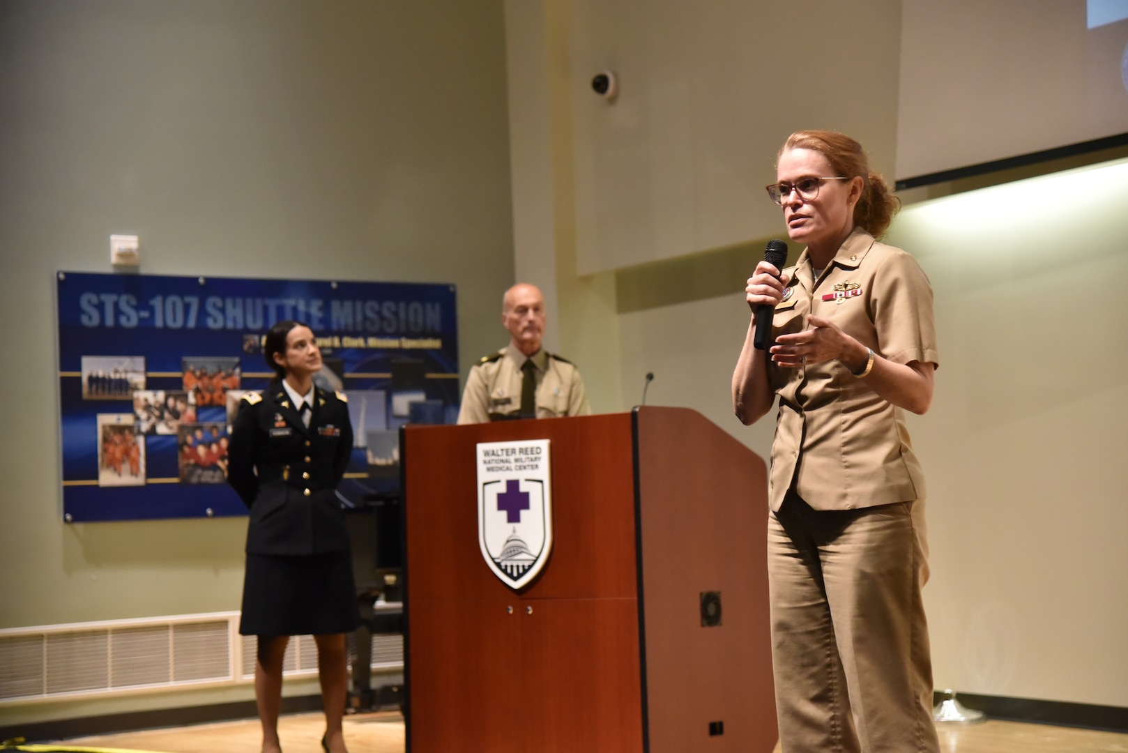 Walter Reed director U.S. Navy Capt. (Dr.) Melissa Austin (3rd from left) introduces U.S. Army Lt. Col. (Dr.) Jamie Diaz Robinson (left) and U.S. Army Chaplain (Maj.) Vincent Bain (center) during a Grand Rounds forum on May 21 in Clark Auditorium in Bethesda, Maryland.