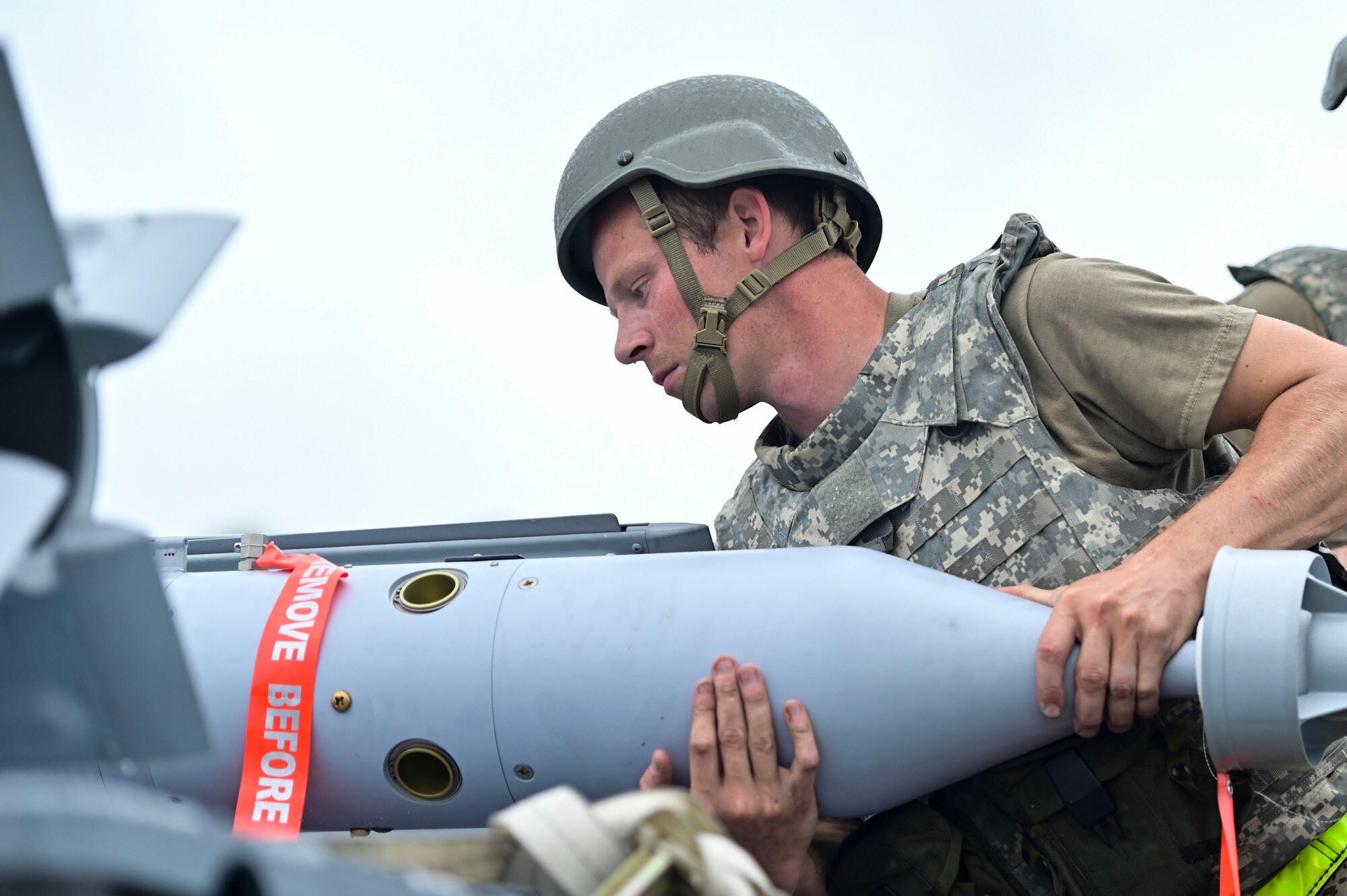 Airmen working on a bomb outside.