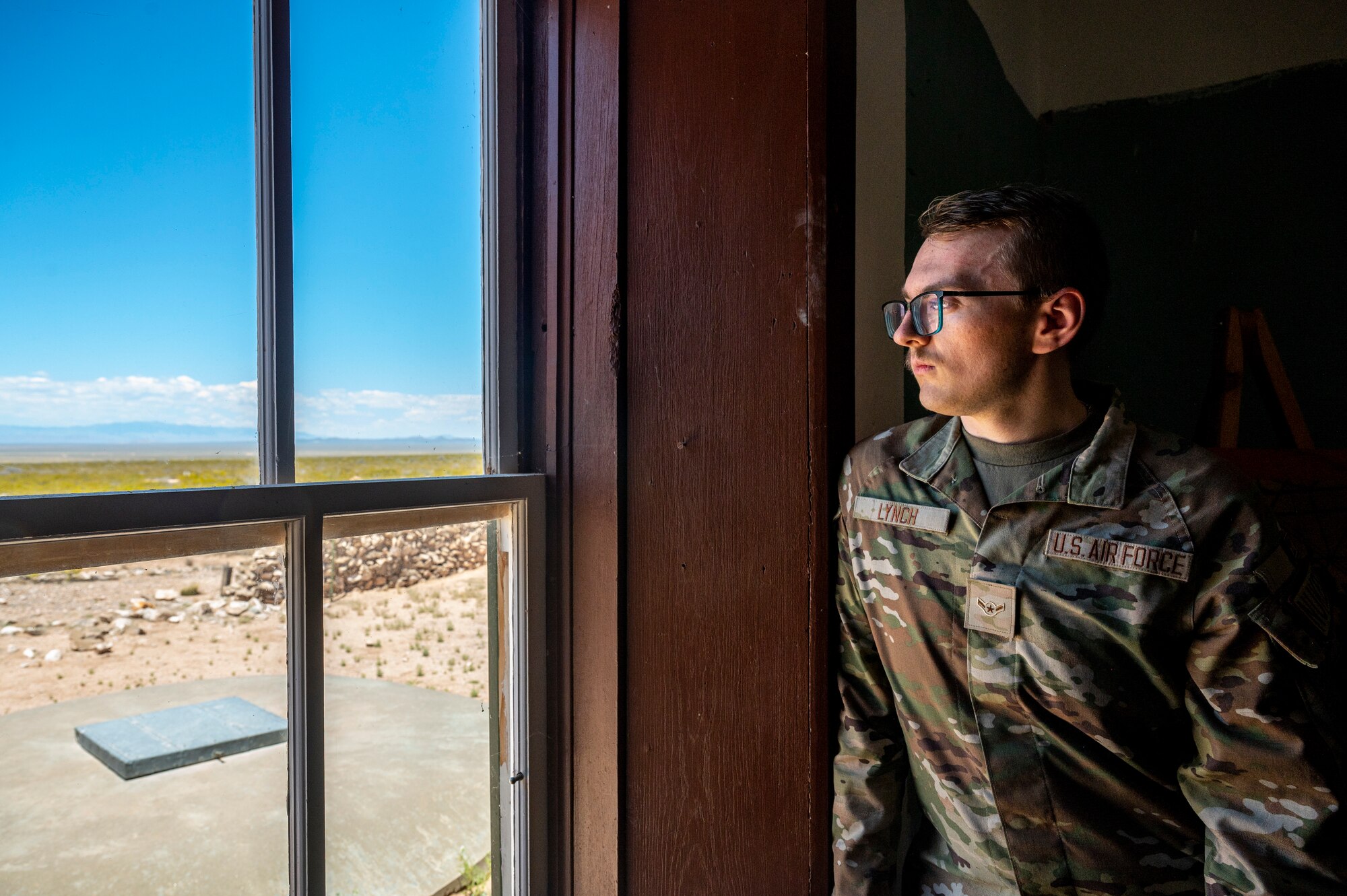 Man looks outside window.