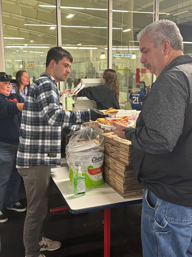 Members of the TRFB WRC sell pizza to raise funds.