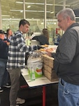 Members of the TRFB WRC sell pizza to raise funds.
