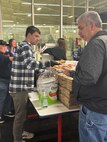Members of the TRFB WRC sell pizza to raise funds.