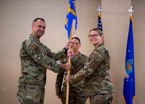 U.S. Air Force Col. Christopher Gonzales, 23rd Medical Group commander, left, passes the guidon to Lt. Col. Megan Martin, 23rd Operational Medical Readiness Squadron incoming commander, during a change of command ceremony at Moody Air Force Base, Georgia, May 23, 2024. Prior to becoming the commander of the 23rd OMRS, she was the public health flight commander at Moody AFB. (U.S. Air Force photo by Airman 1st Class Leonid Soubbotine)
