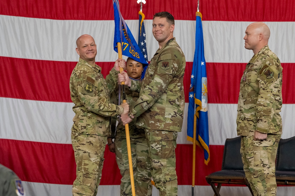 U.S. Air Force Col. Gary Symon, 347th Rescue Group commander, passes the guidon to Lt. Col. Zachary Martin, 347th Operations Support Squadron commander, during a change of command ceremony at Moody Air Force Base, Georgia, May 21, 2024. Martin, an HH-60W Jolly Green II pilot with more than 1600 flying hours, previously served as the 347th OSS director of operations. (U.S. Air Force photo by Senior Airman Deanna Muir)