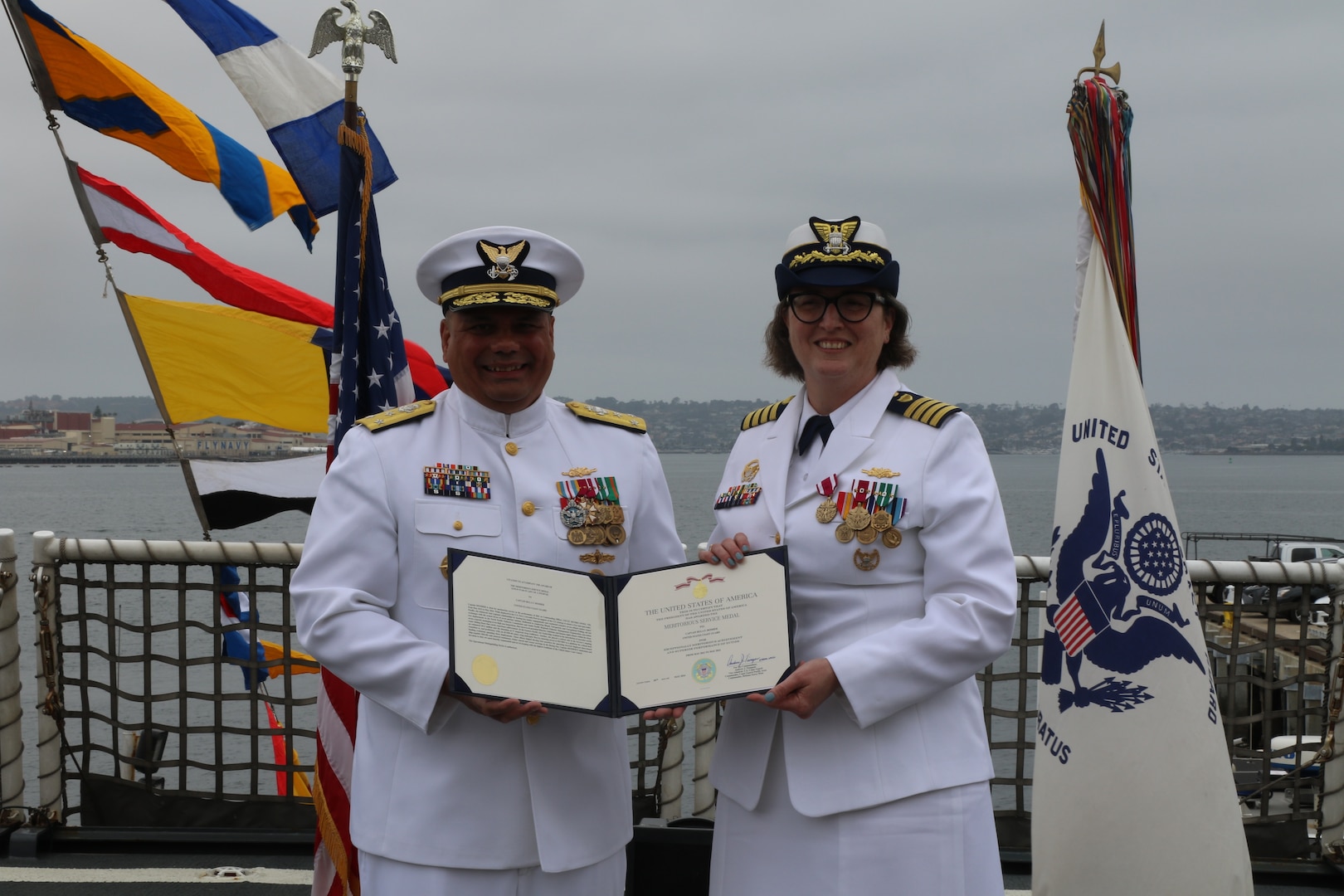 Vice Adm. Andrew J. Tiongson (left), Commander, U.S. Coast Guard Pacific Area, presents Capt. Rula Deisher with a Meritorious Service Medal for her time as commanding officer of the U.S. Coast Guard Cutter Munro (WMSL 755) during the cutter’s change of command ceremony in San Diego, May 30, 2024. Tiongson presided over the ceremony in which Capt. James O’Mara relieved Deisher as Munro’s commanding officer. U.S. Coast Guard photo by Ensign Samika Lewis.