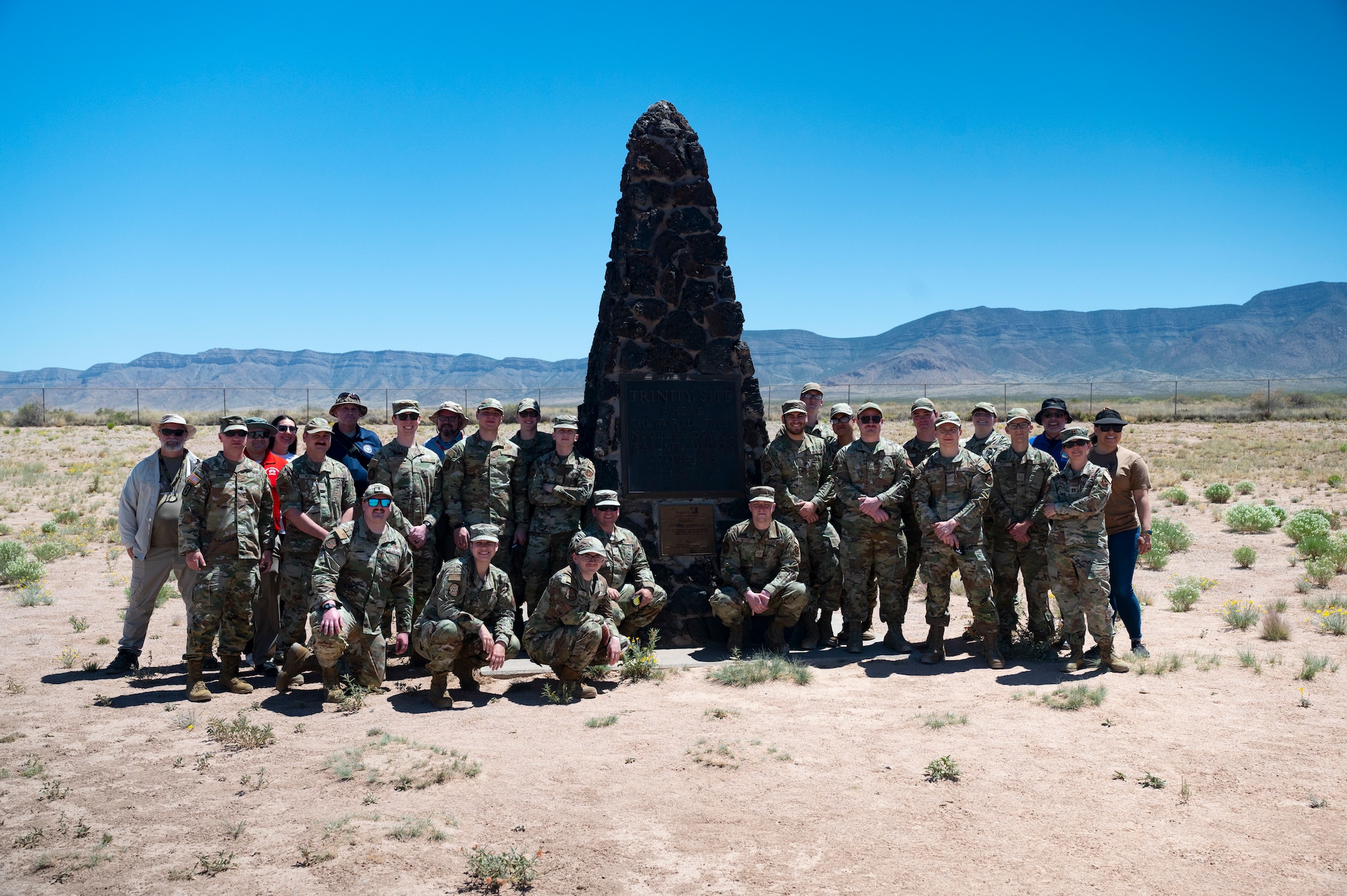 people pose for a group photo at the Trinity Site.