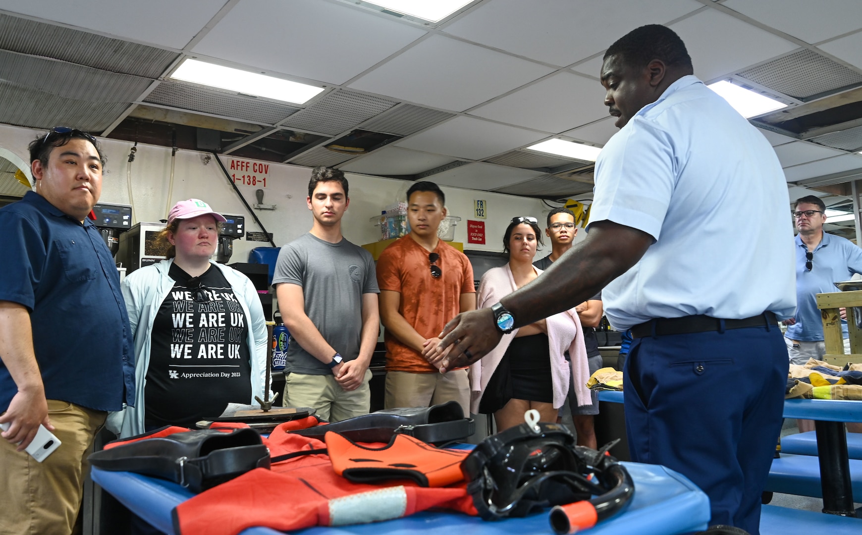Chief Petty Officer Joshua Pollock showcases survival equipment to visiting tourists aboard the medium endurance cutter USCGC Seneca (WMEC 906) during Fleet Week Miami in PortMiami May 7, 2024. During his speech, Pollock explained the meaning and usage of the ship’s bell, firefighting equipment and diving gear used aboard the cutter. (U.S. Coast Guard photo by Petty Officer 2nd Class Diana Sherbs)