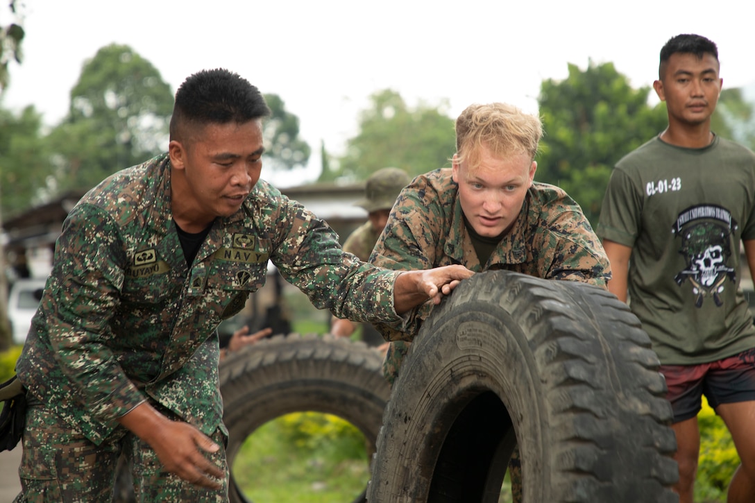 U.S. Marine Corps Cpl. David Anderson, a network administrator with 1st Battalion, 7th Marine Regiment, 1st Marine Division, and a Philippine Marine perform tire flips during the warrior games at Archipelagic Coastal Defense Continuum in Barira, Philippines, May 28, 2024. ACDC is a series of bilateral exchanges and training opportunities between U.S. Marines and Philippine Marines aimed at bolstering the Philippine Marine Corps’ Coastal Defense strategy while supporting the modernization efforts of the Armed Forces of the Philippines. Burke is a native of New Jersey. (U.S. Marine Corps photo by Cpl. Kayla Halloran)