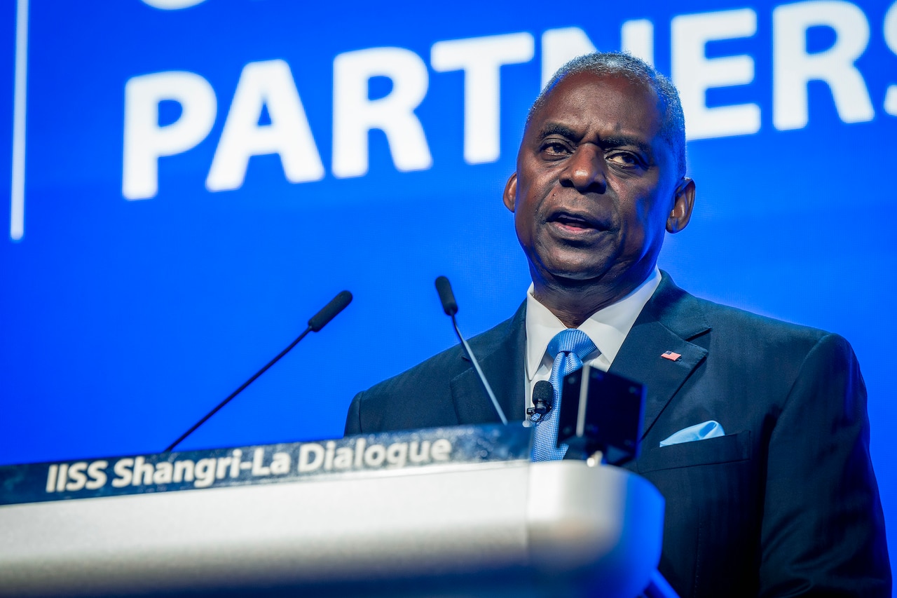 A person in a business suit speaks at a podium.