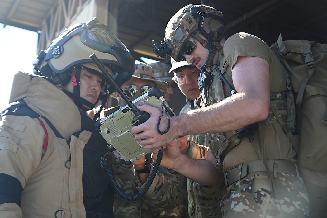 Senior Airman William Kennedy, right, 8th Civil Engineer Squadron explosive ordnance disposal technician, reviews an X-ray of a simulated improvised explosive device with Republic of Korea Air Force Airmen during joint EOD training at Kunsan Air Base, ROK.