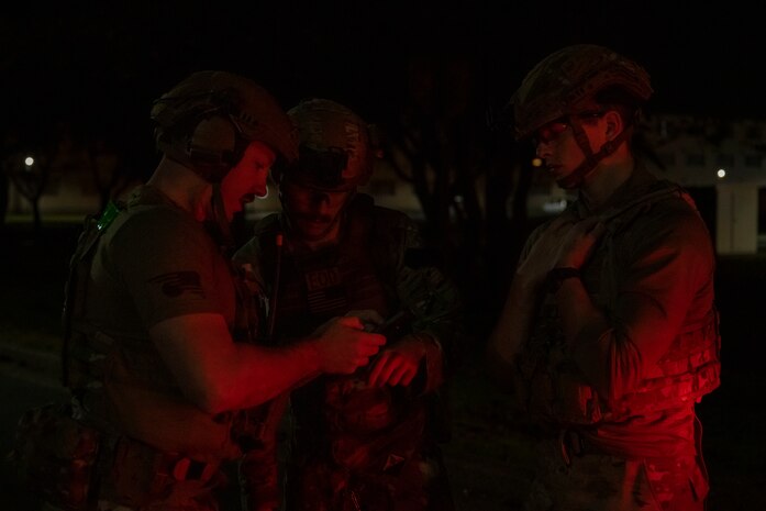 U.S. Air Force Tech. Sgt. Dale Janik, left, Senior Airman Justin Chamberlain, center, and Airman 1st Class Liam Brennan, 35th Civil Engineer Squadron explosive ordnance disposal technicians, review notes.