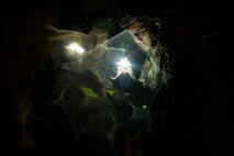 U.S. Air Force Senior Airman Nestor Ryan Casin and Senior Airman Oscar Marin-Martinez, 35th Logistics Readiness Squadron fuels journeymen, review the Airman’s Manual while conducting a post attack reconnaissance sweep during the Beverly Sunrise 24-6 exercise at Misawa Air Base, Japan, Oct. 24, 2024.