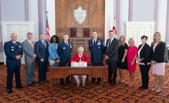 Air Force Culture and Language Center personnel, Air War College Commander Col. Kevin “Buddy” Lee, and AWC Senior Enlisted Leader Chief Master Sgt. Richard Brownlee Jr., watch as Alabama Governor Kay Ivey signs a proclamation on Oct. 10, 2024, declaring November as Alabama’s Second Annual Language, Regional Expertise, and Culture Month in honor of the 9th Annual Air University LREC Symposium at Maxwell Air Force Base, Ala. L-R: Capt. Alexandru Stoica, James Brown, Chad Hermann, Robin Hunter, Col. Kevin “Buddy” Lee, Gov. Ivey, Chief Master Sgt. Richard Brownlee Jr., Howard Ward, Jamie Williams, Dr. Susan Steen, Lori Quiller, and Neka Ponn.