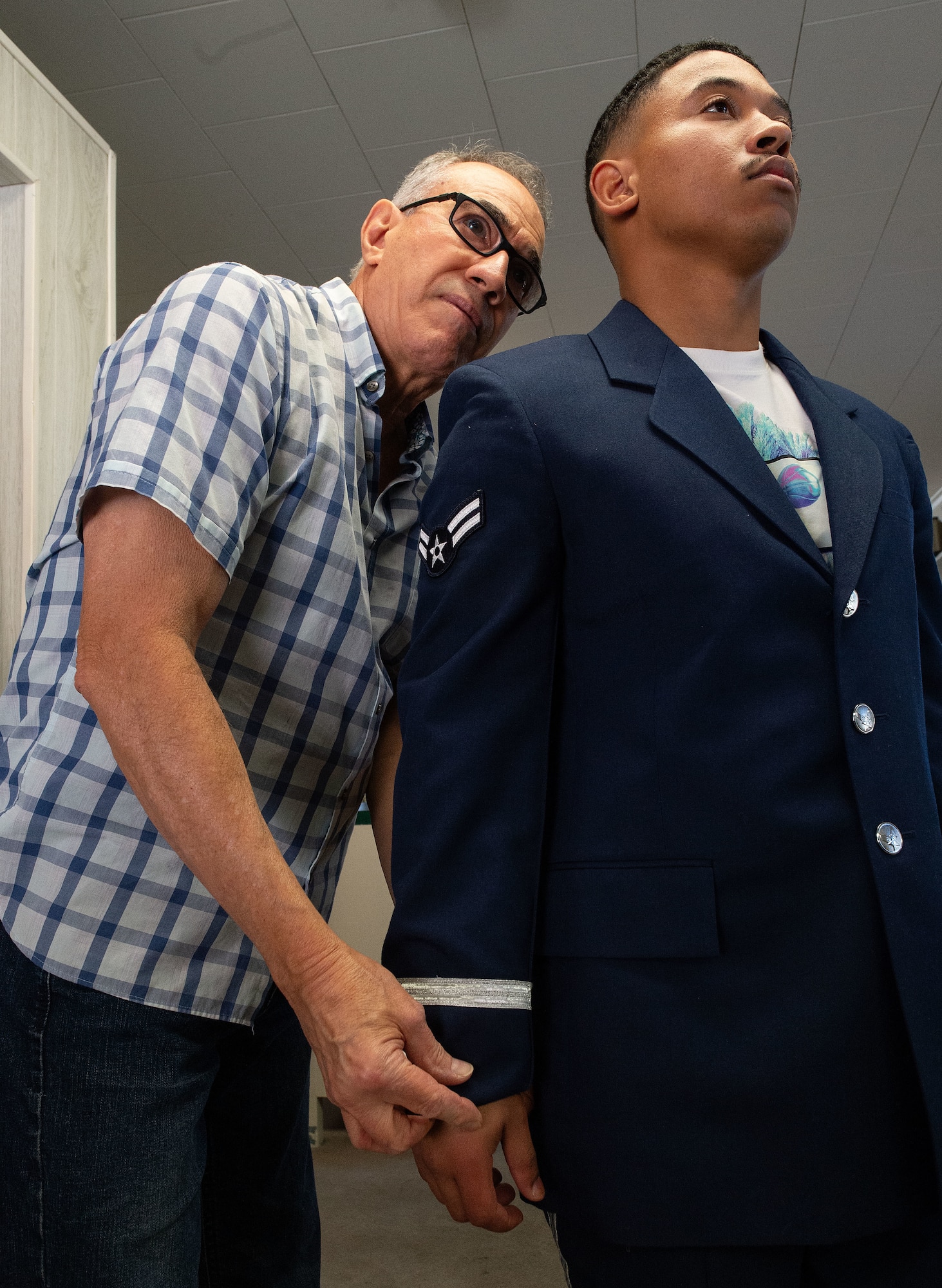 U.S. Airman 1st Class Dallin Sylve, right, 436th Aerial Port Squadron outbound cargo specialist and former base honor guard member, gets his ceremonial guardsman service coat fitted by Harry Santiago, professional tailor, in Dover, Delaware, Oct. 25, 2024. Eleven former BHG members went to Santiago’s place of business to get their ceremonial guardsman uniform fitted for the upcoming presidential inauguration ceremony scheduled in January 2025. (U.S. Air Force photo by Roland Balik)