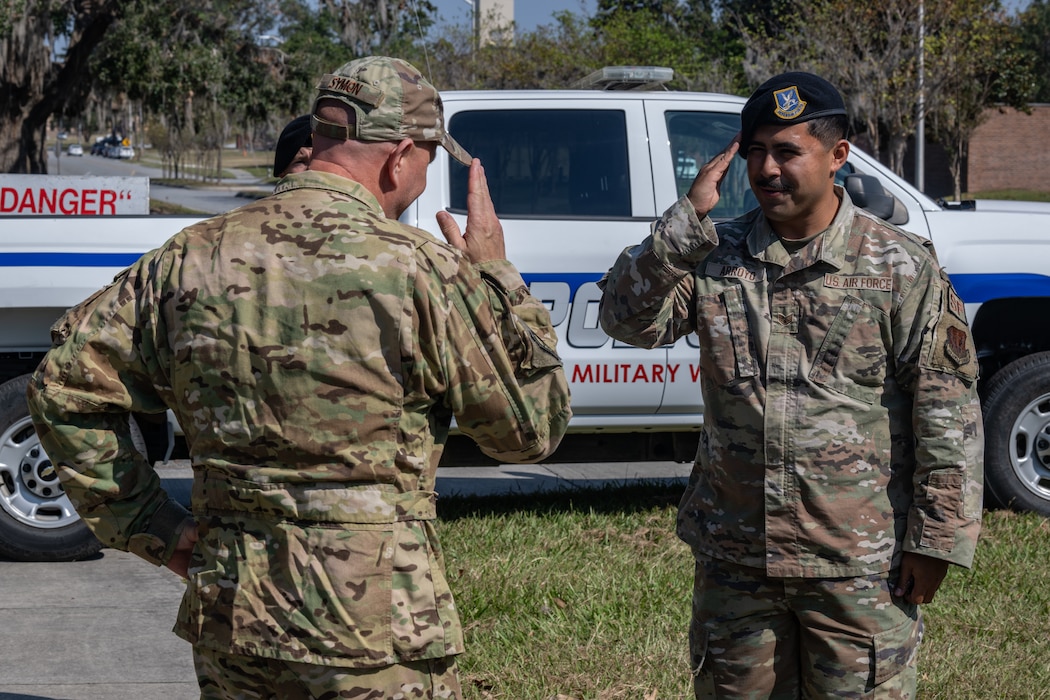 U.S. Air Force Col. Gary Symon, 23rd Wing acting commander, coins Staff Sgt. Marco Arroyo, 23rd Security Forces Squadron military working dog handler, at Moody Air Force Base, Georgia, Oct. 28, 2024. Leadership recognized Arroyo for his hard work and dedication within his unit. (U.S. Air Force photo by Airman 1st Class Iain Stanley)