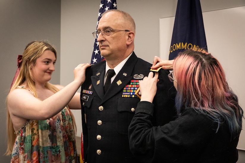 Col. Kevin Jones is promoted by his daughters, Samantha and Sandra.