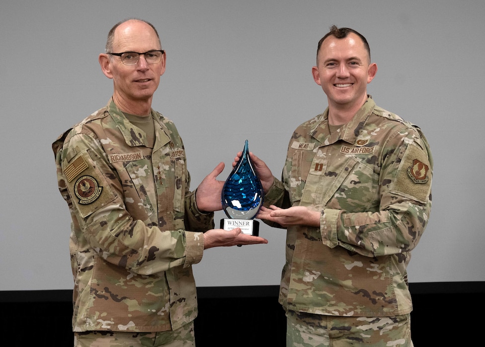 Two Airmen with a trophy.