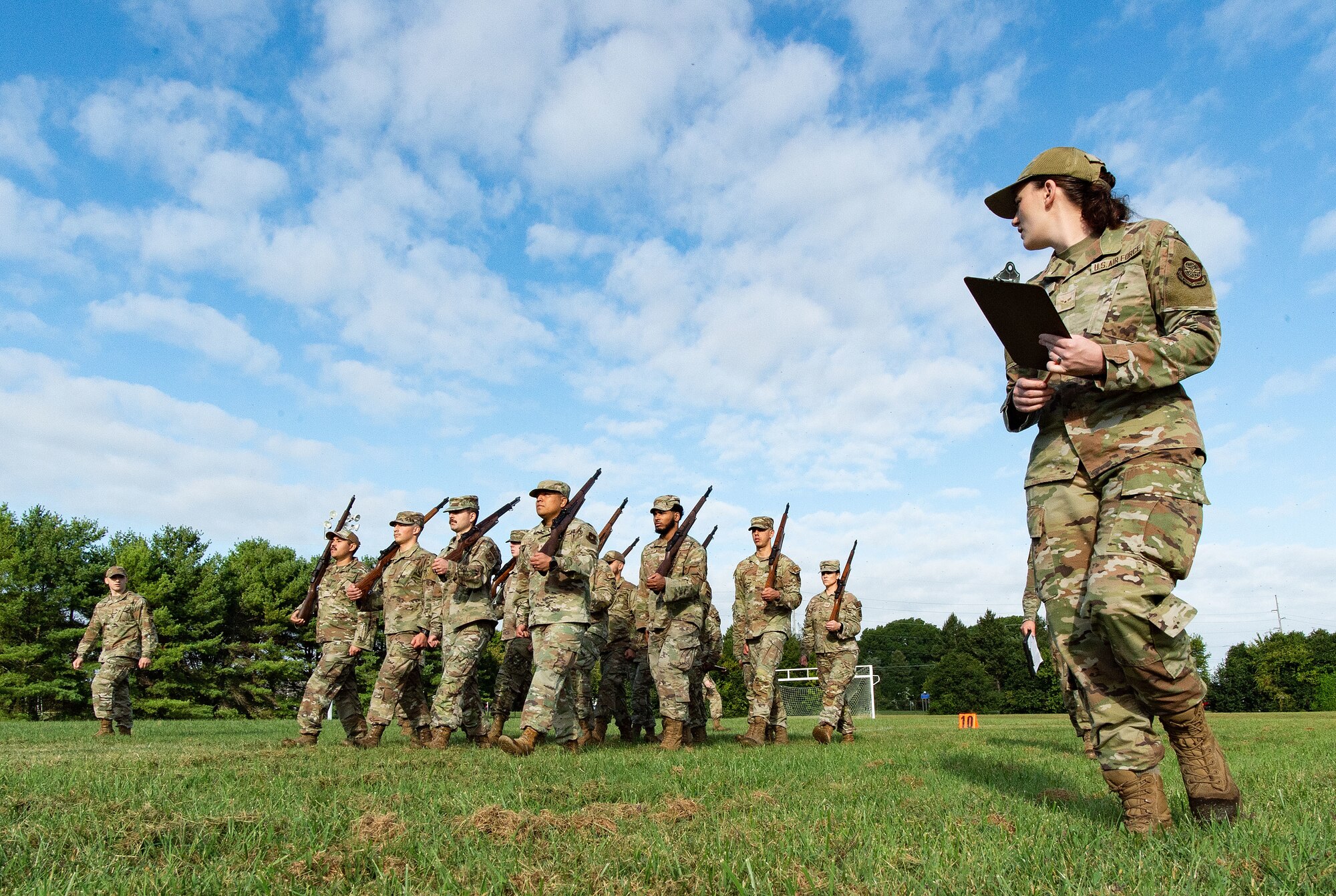 U.S. Air Force Airman 1st Class Madison Smith, right, and Senior Airman Sckylar Huffman, left, Dover Base Honor Guard cadre, evaluate former BHG members marching in formation at the base track at Dover Air Force Base, Delaware, Sept. 6, 2024. Seventeen former BHG members went through a tryout process for ceremonial guardsman positions needed for the upcoming presidential inauguration ceremony scheduled in January 2025. (U.S. Air Force photo by Roland Balik)