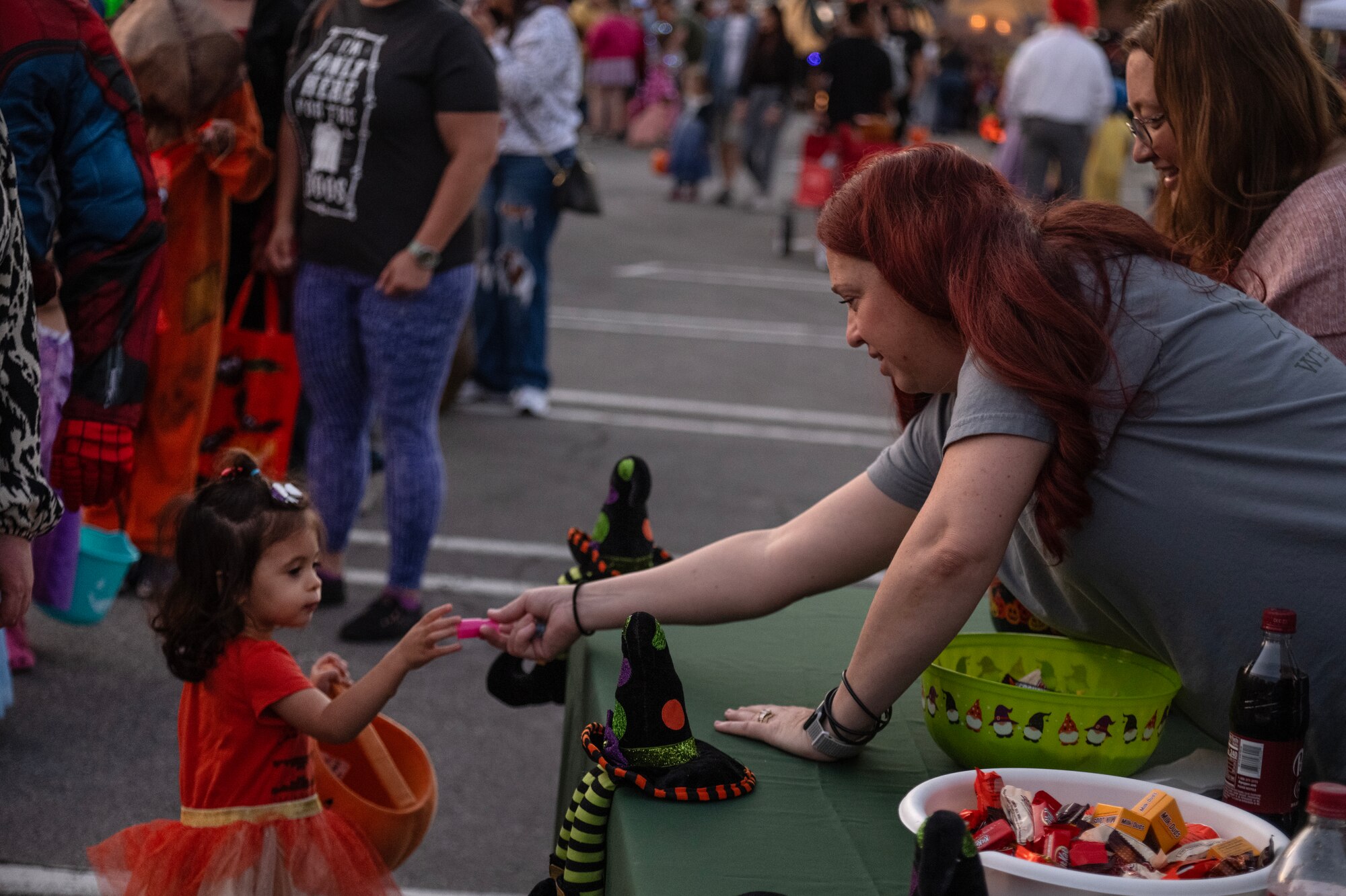 Cynthia Oxendale, Mayroad base housing leasing manager, hands a piece of candy to a child during a Halloween event.