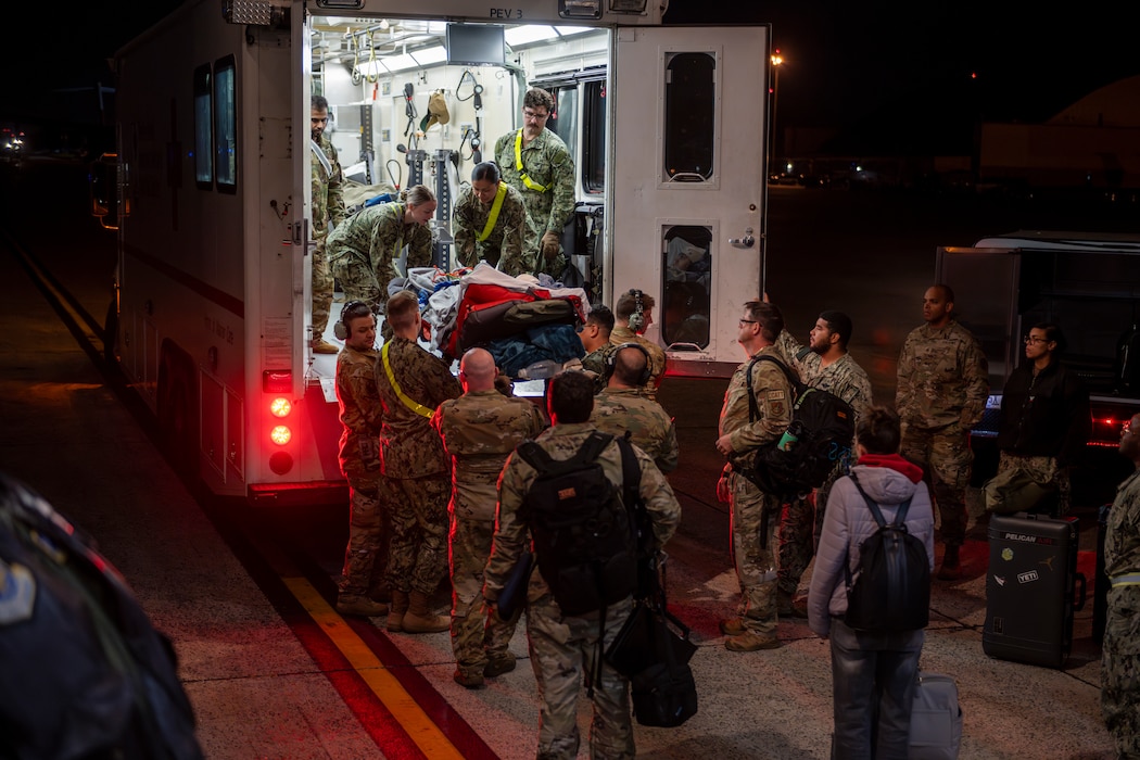 Airmen load a patient from a C-17 into an ambulance