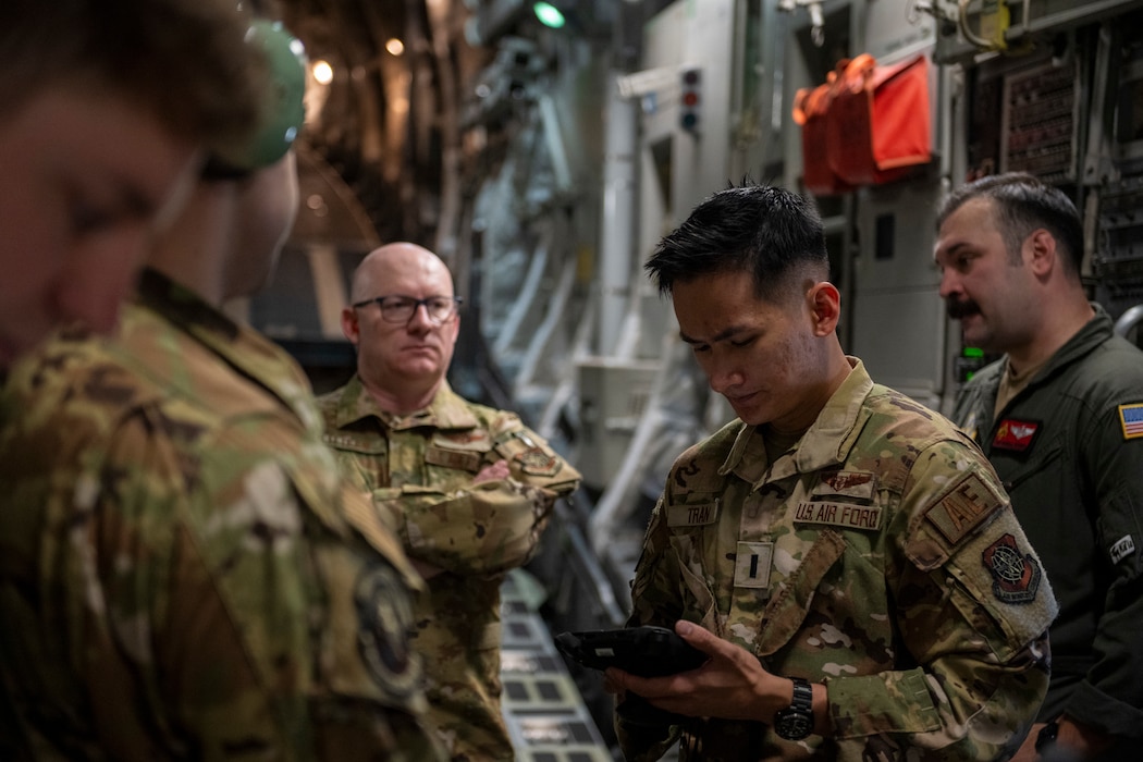 Airmen gives brief to other Airmen aboard a C-17