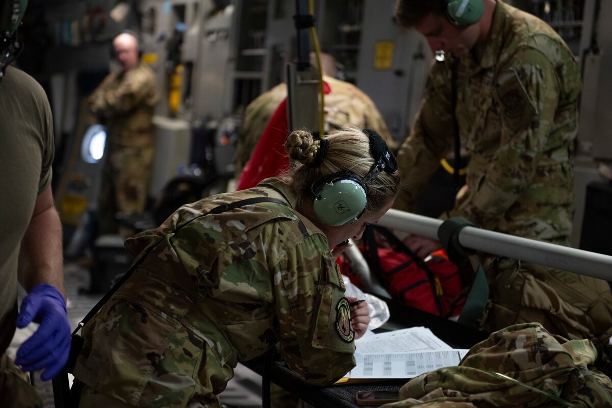 Airmen checks a patient's medical records while on a C-17