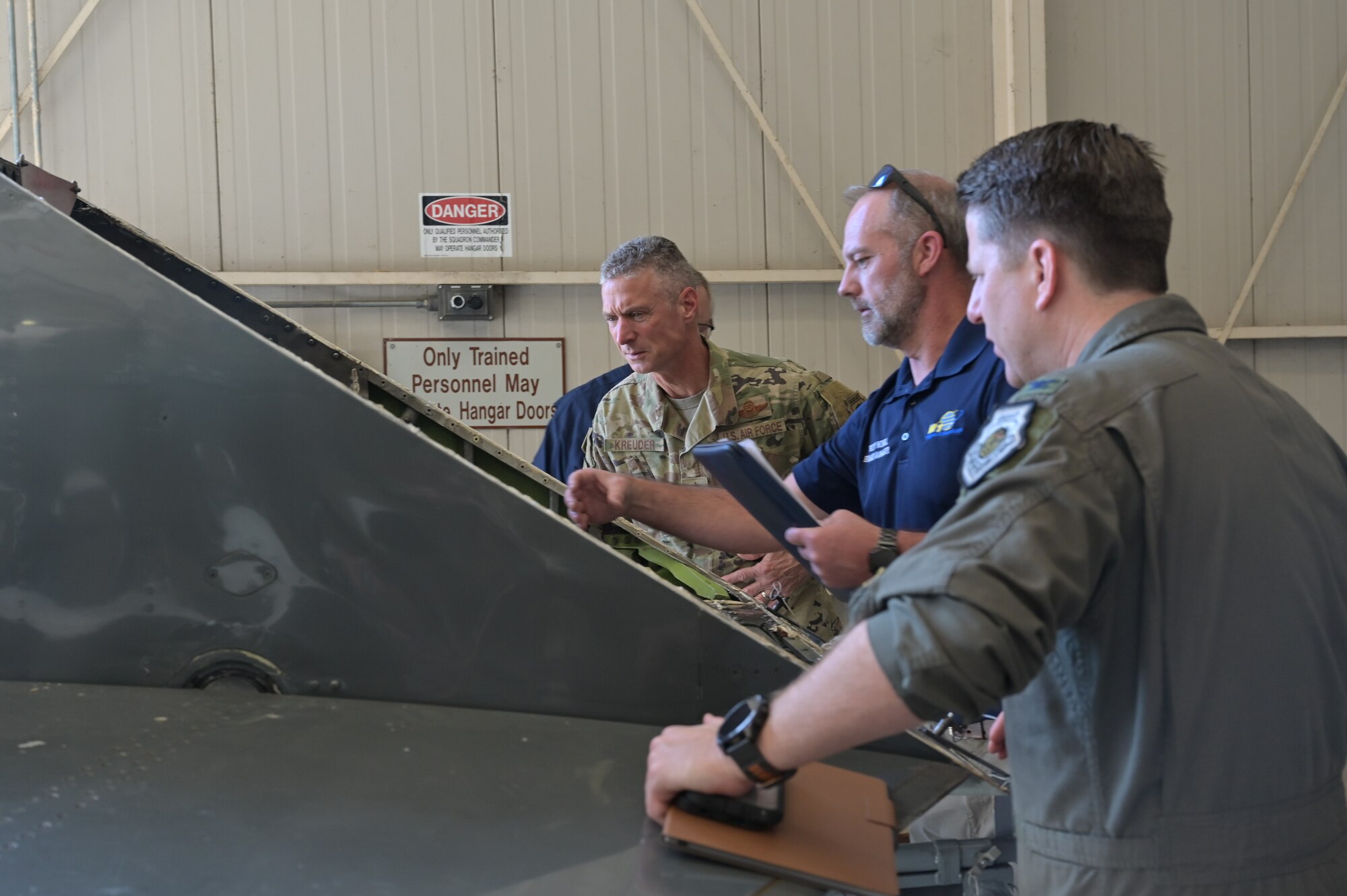 Maj. Gen. Kreuder inspects aircraft parts with maintenance personnel.
